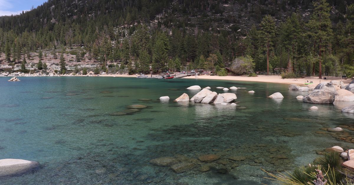 Stunning view of Lake Tahoe with clear waters, forested shores, and rocky formations.
